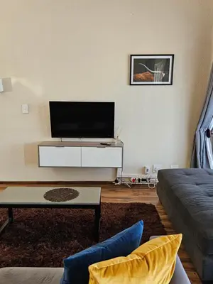 a living room with a flat screen tv on a wall at Pine View Guesthouse Graskop in Graskop
