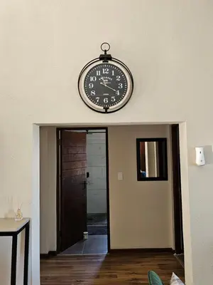 a clock hanging on the wall above a hallway at Pine View Guesthouse Graskop in Graskop