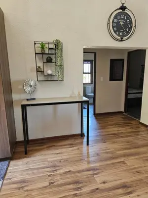 a room with a table and a clock on the wall at Pine View Guesthouse Graskop in Graskop