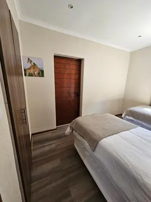 a bedroom with a bed and a wooden door at Pine View Guesthouse Graskop in Graskop