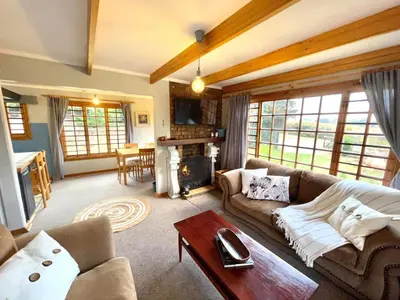 a living room with a couch and a table at The Hedge at Dullstroom Cottage in Dullstroom