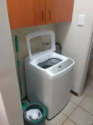 a washing machine with its lid up in a bathroom at Ebeneezer Self-Catering Guesthouse in the Lowveld in Sabie