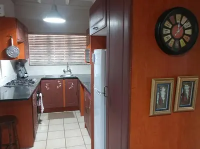 a kitchen with a clock on the wall and a counter at Ebeneezer Self-Catering Guesthouse in the Lowveld in Sabie