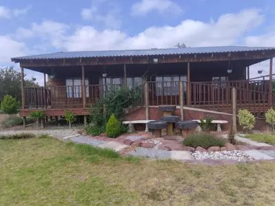 a log cabin with a deck and a yard at Mogale Royal Gardens in Polokwane