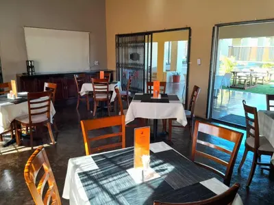 a dining room with tables and chairs at Mogale Royal Gardens in Polokwane
