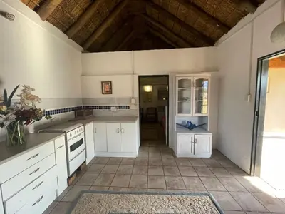 a kitchen with white cabinets and a tile floor at Vanross Self Catering Accommodation in Thabazimbi