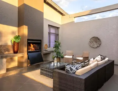 a living room with a couch and a fireplace at Sofala Lodge in Mokopane