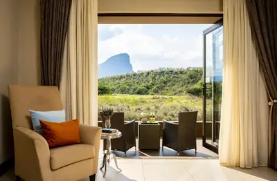a living room with a view of a mountain at Sofala Lodge in Mokopane