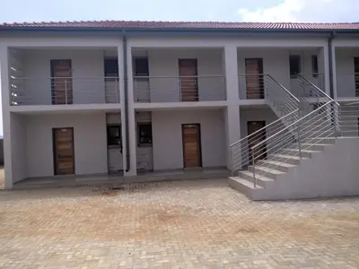 a large white building with stairs in front of it at Thomsons Lodge in Polokwane