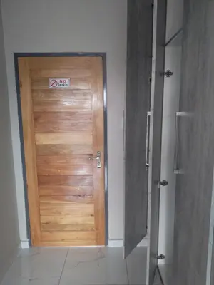 a wooden door with a sign on it in a room at Thomsons Lodge in Polokwane