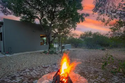a fire pit in a yard with a tree at Palahala in Marloth Park