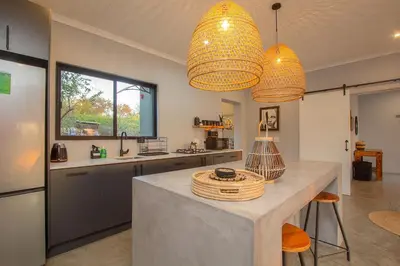 a kitchen with two chandeliers and a counter top at Palahala in Marloth Park