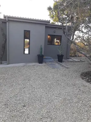 a house with a gravel yard in front of it at Palahala in Marloth Park