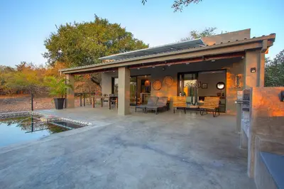a house with a patio and a pond at Palahala in Marloth Park
