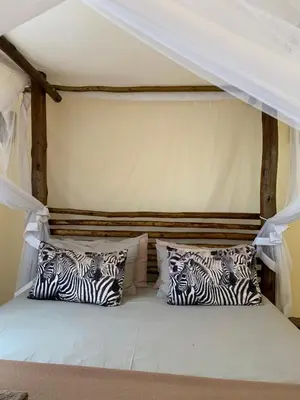 a bed with zebra pillows in a room at iMbamuweti Cottage in Grietjie Nature Reserve