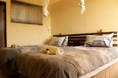 a bedroom with two beds with stuffed animals on them at iMbamuweti Cottage in Grietjie Nature Reserve