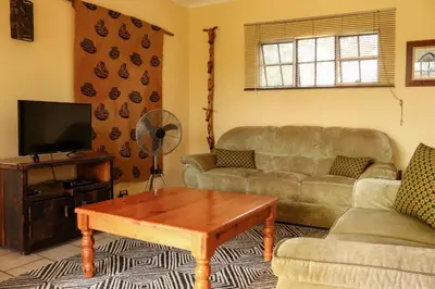 a living room with a couch and a coffee table at iMbamuweti Cottage in Grietjie Nature Reserve