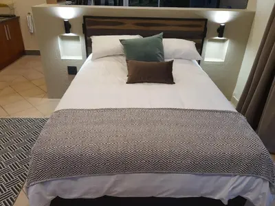 a large bed with two pillows on top of it at Bikkurim Inn in Nelspruit