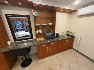 a kitchen with a sink and a mirror at Bikkurim Inn in Nelspruit