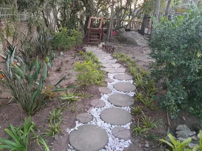 a garden with a path with rocks and a gate at Bikkurim Inn in Nelspruit