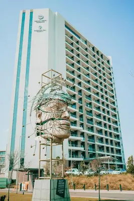 a large building with a sculpture in front of it at 703 Menlyn Maine Residences, The Trilogy in Pretoria