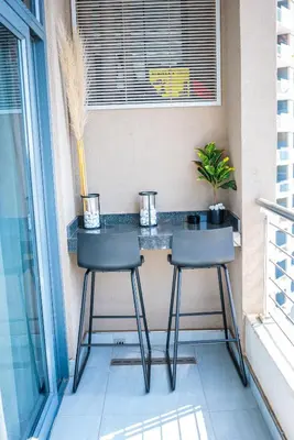 a balcony bar with two chairs and a table at 703 Menlyn Maine Residences, The Trilogy in Pretoria