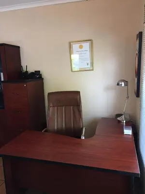 a desk with a chair and a desk with a lamp at Harambi in Nelspruit