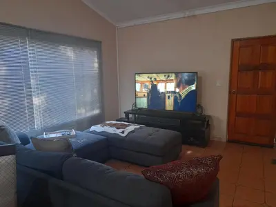 a living room with a couch and a flat screen tv at Harambi in Nelspruit