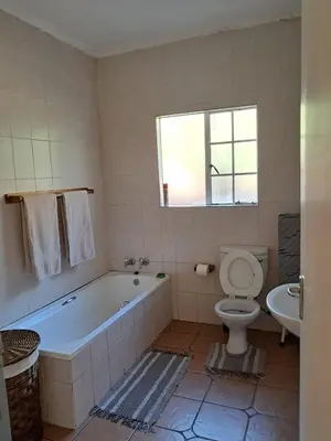 a bathroom with a tub and a toilet and a sink at Harambi in Nelspruit