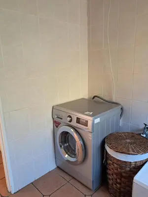 a washing machine in a bathroom with a basket at Harambi in Nelspruit