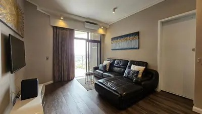 a living room with a leather couch and a window at Menlyn Maine Unit 1421 in Pretoria