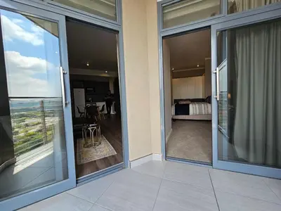 a balcony with sliding glass doors with a view of a bedroom at Menlyn Maine Unit 1421 in Pretoria