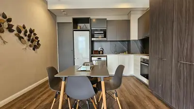 a kitchen with a table and chairs in a room at Menlyn Maine Unit 1421 in Pretoria