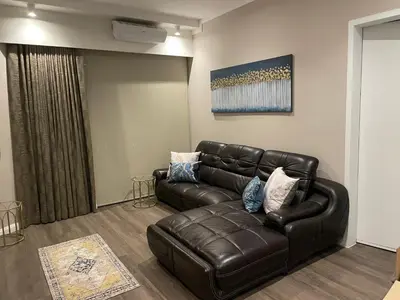 a living room with a leather couch in a room at Menlyn Maine Unit 1421 in Pretoria