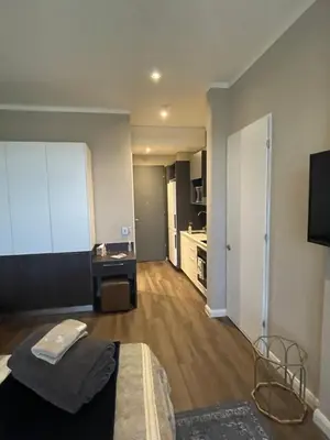 a bedroom with a bed and a desk in a room at Menlyn Maine Unit 1420 in Pretoria
