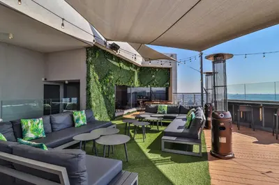 a living room with couches and tables on a balcony at Menlyn Maine Unit 1420 in Pretoria
