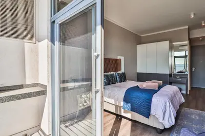 a bedroom with a bed and a sliding glass door at Menlyn Maine Unit 1420 in Pretoria