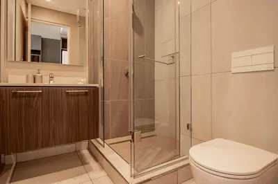 a bathroom with a shower and a toilet and a sink at Menlyn Maine Unit 1420 in Pretoria