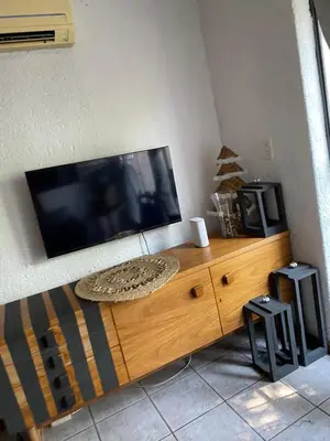a flat screen tv sitting on top of a wooden entertainment center at HomeSweetHome City Apartment in Nelspruit