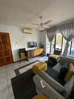 a living room with a couch and a tv at HomeSweetHome City Apartment in Nelspruit