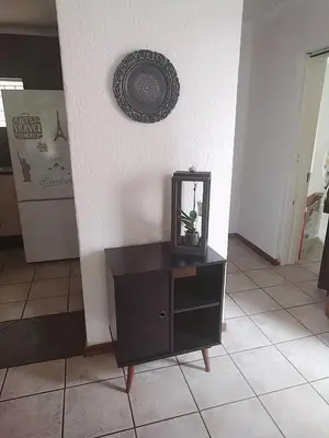 a black dresser with a mirror on a wall at HomeSweetHome City Apartment in Nelspruit