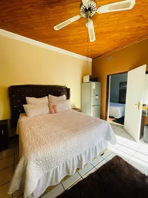 a bedroom with a bed and a ceiling fan at Mighty7 Bed and Breakfast Guesthouse in Pretoria