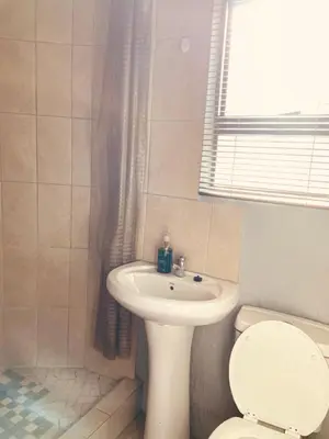a bathroom with a white sink and a toilet at Mighty7 Bed and Breakfast Guesthouse in Pretoria