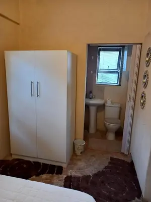 a bathroom with a white cabinet and a toilet at Mighty7 Bed and Breakfast Guesthouse in Pretoria