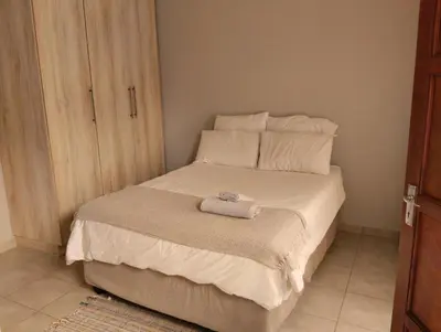 a small bedroom with a bed with a towel on it at Rethapaki Guesthouse in Secunda