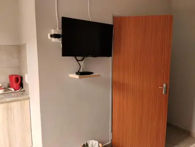 a flat screen tv hanging on a wall next to a door at Rethapaki Guesthouse in Secunda