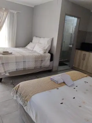 a bedroom with two beds with towels on the floor at Rethapaki Guesthouse in Secunda