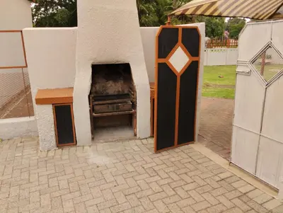 a barbecue grill in a building next to a fence at Rethapaki Guesthouse in Secunda