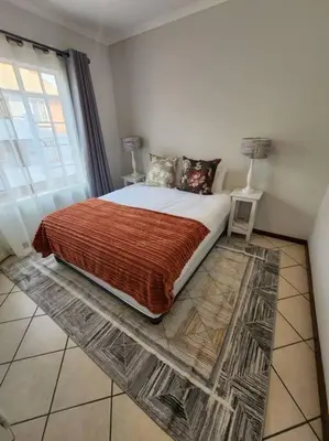 a bedroom with a bed with a large window at 56 - Elegant 2 bed apartment next to Gautrain Centurion in Centurion