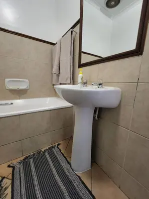 a bathroom with a sink and a mirror and a tub at 56 - Elegant 2 bed apartment next to Gautrain Centurion in Centurion
